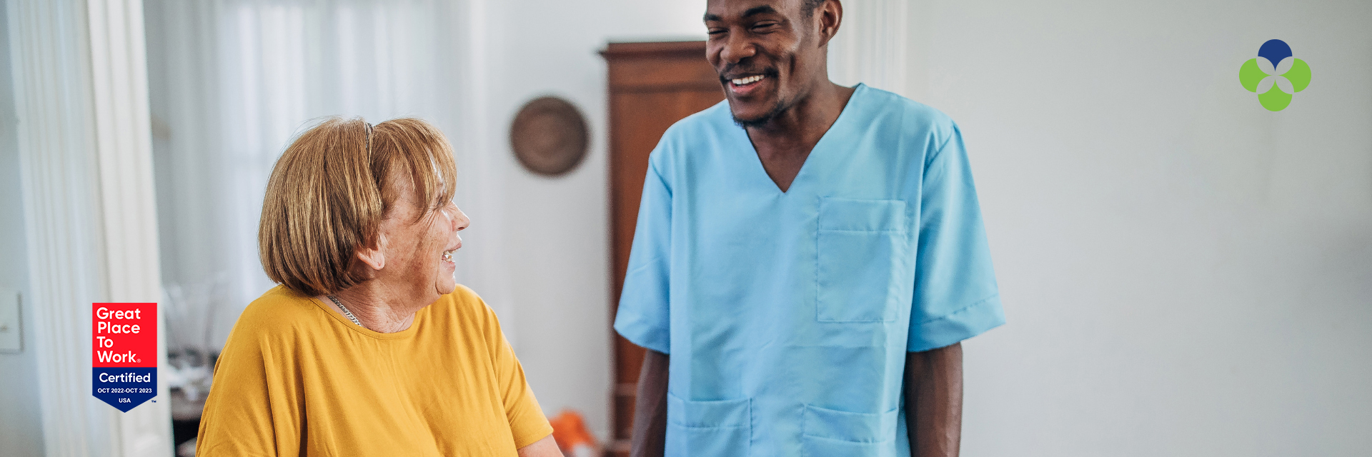 CNA with dark hair and patient both smiling at camera