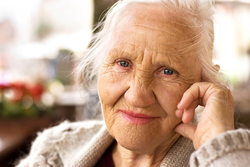 Close up of elderly woman with her hand resting on her face