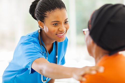 African american young nurse smiling at elderly woman with her back to the camera